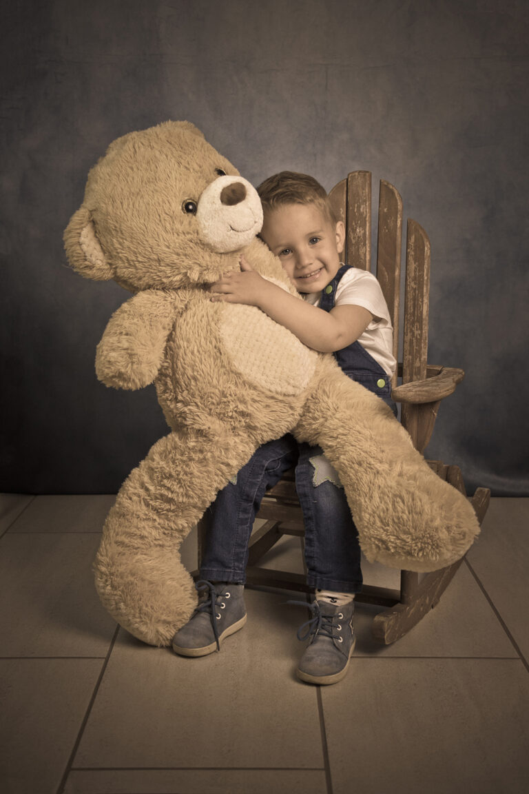 Kid hugging a big plush by Attila Kapodarca